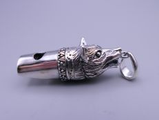 A silver whistle in the shape of a fox. 3.5 cm long.