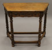 A carved oak single drawer side table. 88 cm wide.