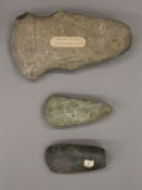 Three stone axe heads. The largest 18 cm long.