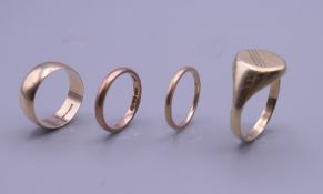 Three 9 ct gold wedding bands and a 9 ct gold signet ring. 10 grammes.