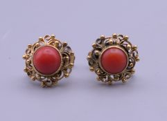 A pair of gold and coral earrings. Each 1 cm diameter. 4 grammes total weight.