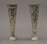 A pair of silver embossed bud vases. Each 16.5 cm high. 10 troy ounces loaded.