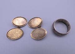 A pair of silver gilt cufflinks and a silver wedding band. Ring size N/O.