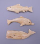 Three bone carvings, a whale, a dolphin and a fish. The former 8 cm long.