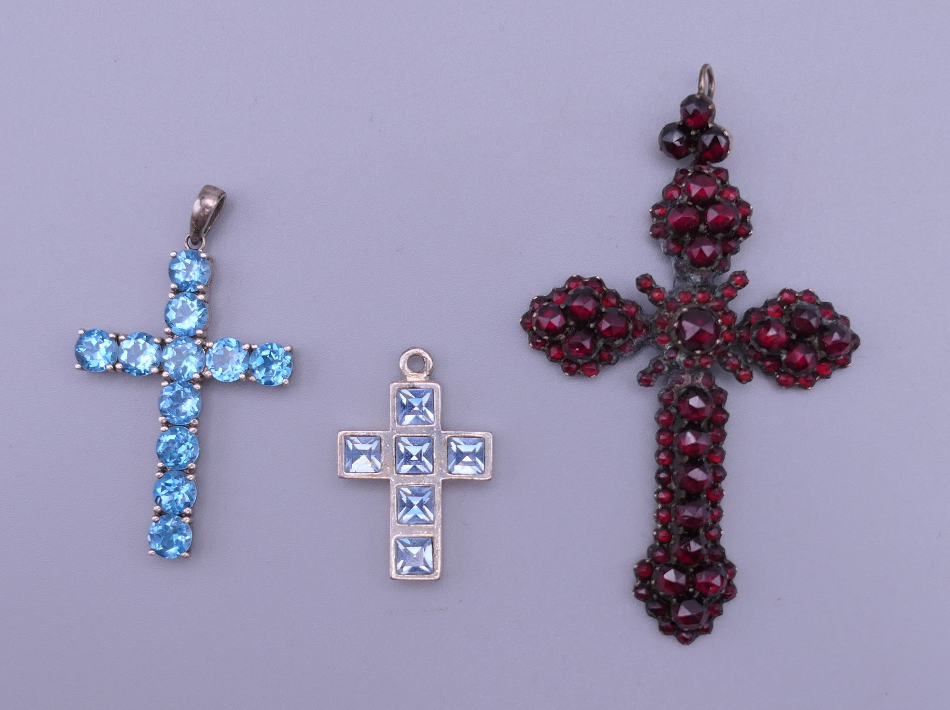 A sterling silver blue stone cross pendant,