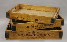 A set of three wooden trays. The largest 56 cm long.