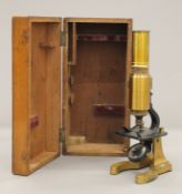 A small Victorian boxed brass microscope. The box 24 cm long.