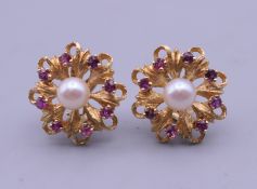 A pair of 14 ct gold ruby and pearl earrings. Each 2 cm diameter. 10 grammes total weight.