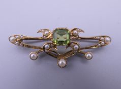 An Art Nouveau 15 ct gold seed pearl and peridot brooch. 4 cm wide. 3.4 grammes total weight.