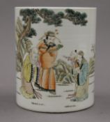 A Chinese porcelain brush pot decorated with figures. 15 cm high.