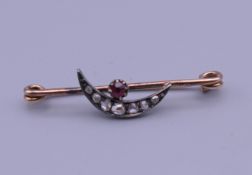 An 18 ct gold diamond and ruby crescent moon bar brooch. 1.8 grammes total weight.