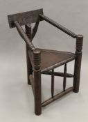 A carved oak corner chair. 64 cm wide.