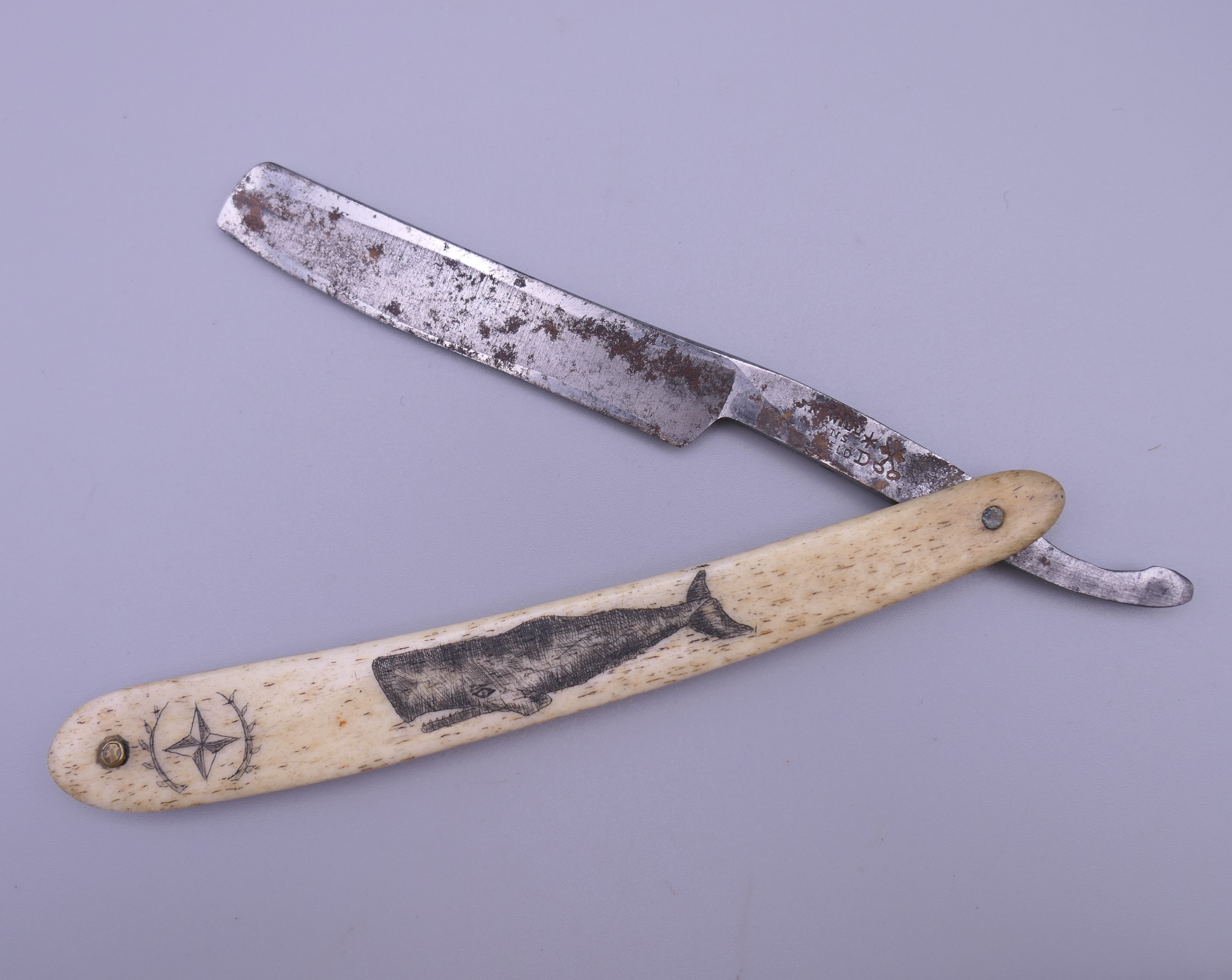 A cut throat razor with scrimshaw decoration. 16 cm long closed.