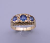 An 18 ct gold diamond and sapphire ring. Ring size Q/R. 3 grammes total weight.