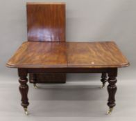 A Victorian mahogany extending dining table, including one extra leaf.