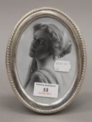 A silver oval picture frame. 12.5 x 16.5 cm.