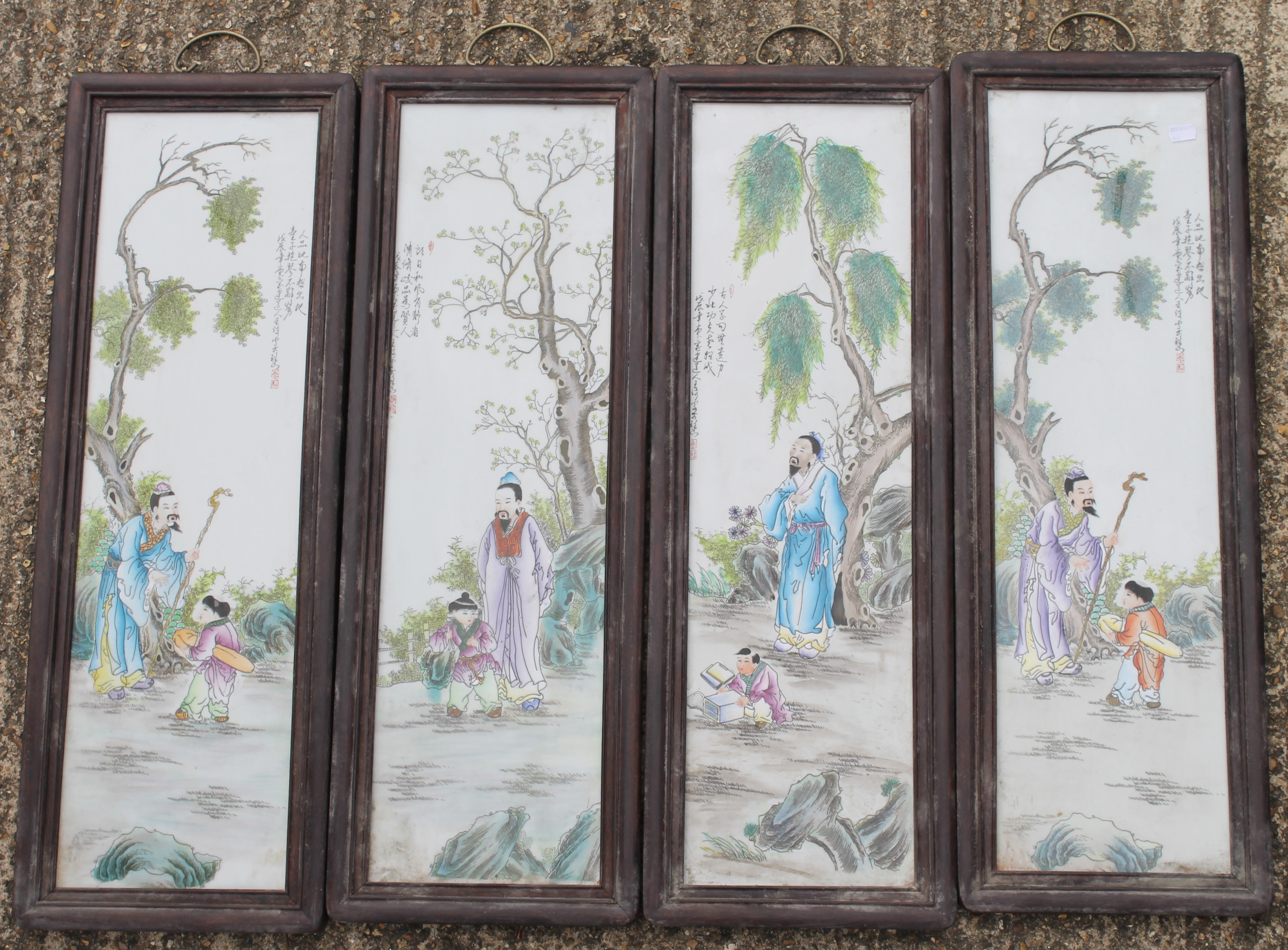 A set of four framed Chinese porcelain plaques. 27 x 80 cm.