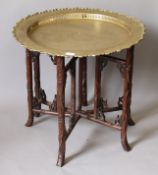 A Chinese rosewood folding brass tray topped table. 66 cm diameter.