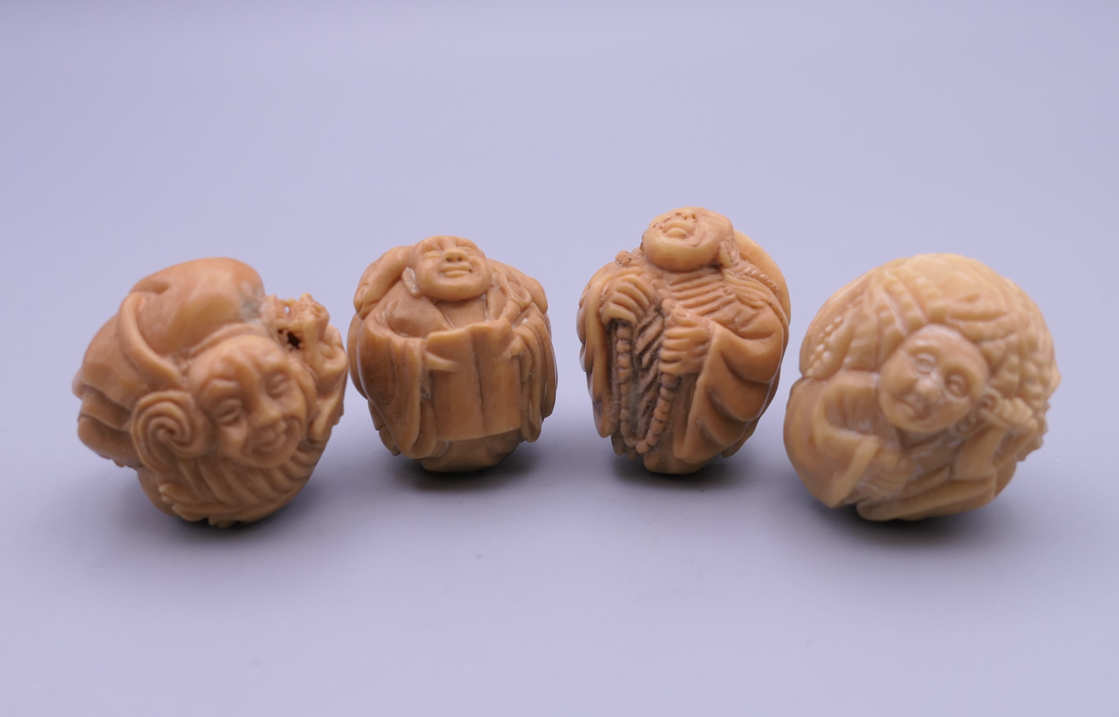 Four carved bone netsuke. Each approximately 3 cm wide.