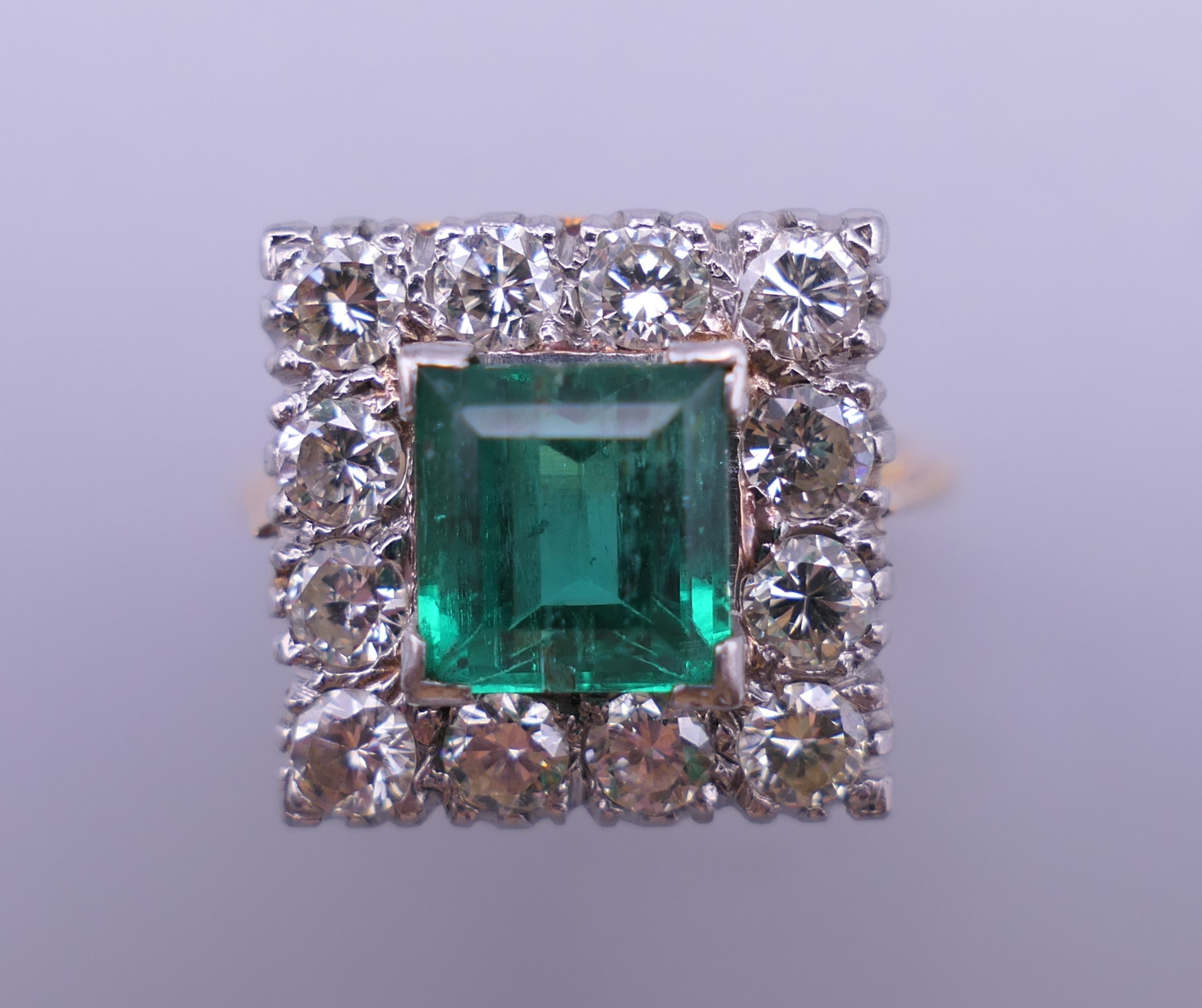 An 18 ct gold and platinum emerald and diamond ring. Ring size H/I (with previous sizing mounts). 1.