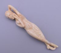 A bone carving of a medical figure. 11 cm long.