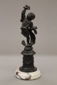 A small bronze of a cherub on a marble plinth base, signed. 21 cm high.