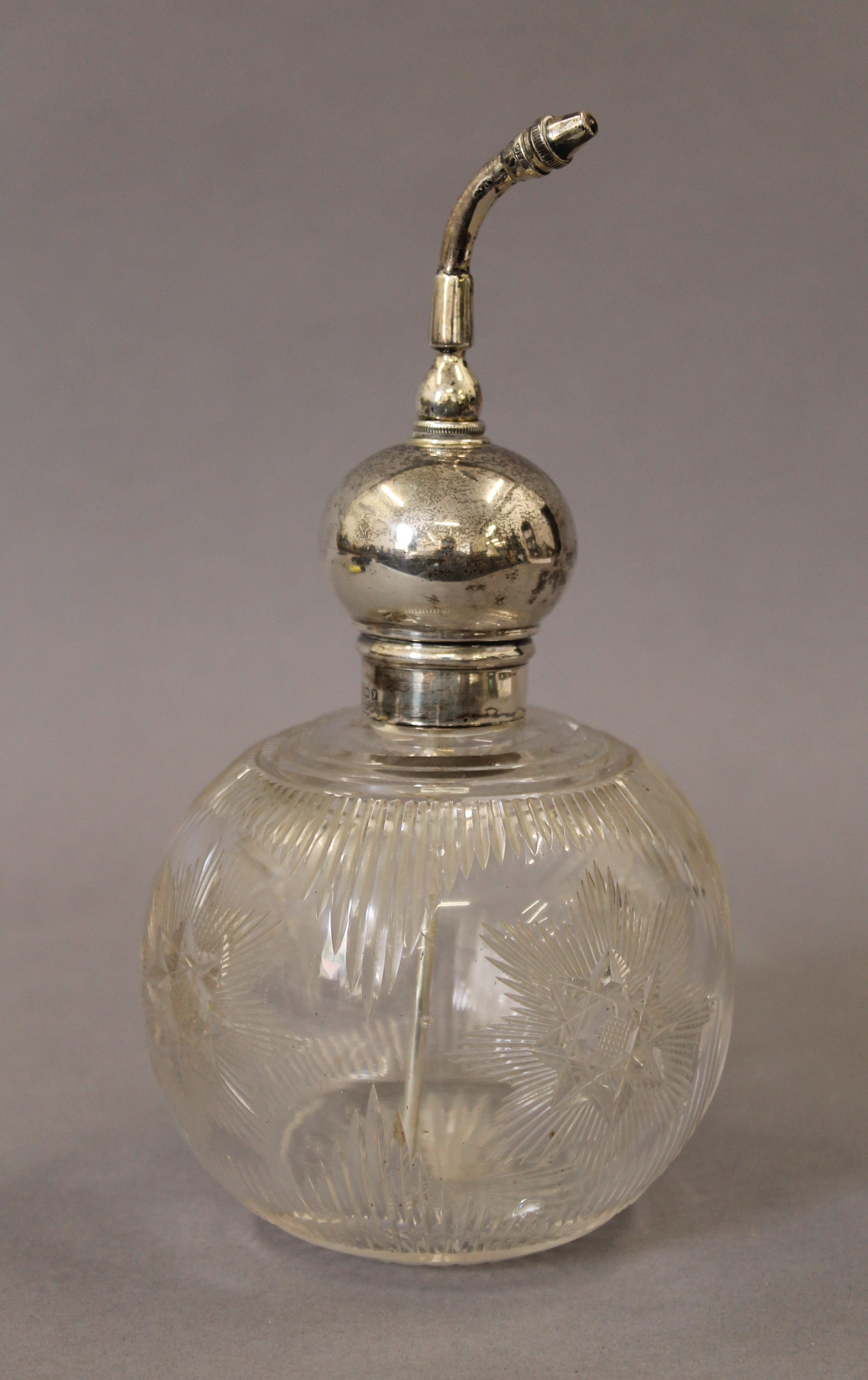 A silver topped atomiser scent bottle. 19.5 cm high.