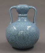 A Chinese light blue twin handled pottery vase. 21 cm high.