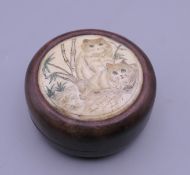A wood and bone box decorated with cats. 6 cm diameter.