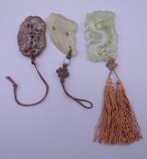 Three Chinese carved jade pendants. The largest 6 cm high.