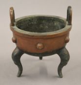 A Chinese bronze censer with loop handles. 14 cm high.