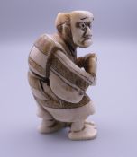 A 19th century Japanese ivory netsuke of a masked man. 5 cm high.