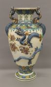 A large Japanese pottery vase decorated with dragons. 55 cm high.