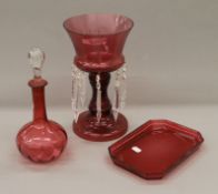 A cranberry glass lustre, decanter and a small tray. The former 30.5 cm high.