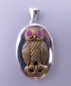 A silver locket decorated with an owl. 4.5 cm high.