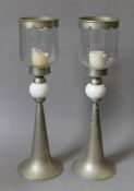 A pair of beaten pewter porcelain mounted candle holders with glass storm shades. 85 cm high.