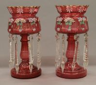 A pair of Victorian florally painted cranberry glass lustres. Each 34 cm high.