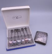 A silver cigarette case and a boxed set of white metal teaspoons. The former 7 cm wide.