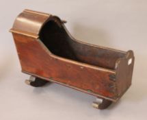 A 19th century mahogany doll cradle. 39 cm long.