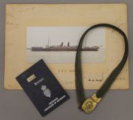 A photograph of RMS Persia with signatures, together with a Naval belt and handbook.