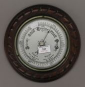 An oak framed aneroid barometer. 26 cm diameter.