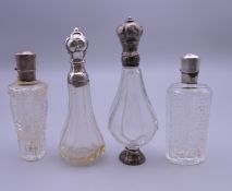 Four French silver topped scent bottles. The largest 10.5 cm high.