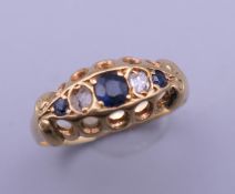 An 18 ct gold diamond and sapphire ring. Ring size M. 2.3 grammes total weight.