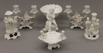 A quantity of Continental porcelain, set with cherubs and putto. The largest 18.5 cm high.