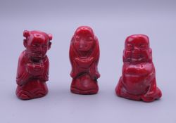 Three carved coral buddha figures. The largest 4.5 cm high.