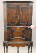 An early 20th century carved oak barley twist corner cabinet. 180 cm high.