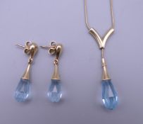 A 9 ct gold blue topaz set slider necklace and a pair of earrings en-suite.