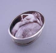 A silver pill box depicting a nude. 3.5 cm wide.