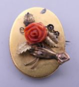 A 15 ct gold and coral brooch. 3.5 cm high. 7.7 grammes total weight.