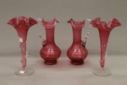 Two cranberry glass jugs and two cranberry glass flutes. The latter each 27 cm high.